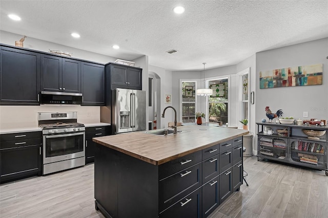 4027 Lakeside Reserve Ct, Orlando, FL 32810 - kitchen with a sink, stainless steel appliances, butcher block countertops, and dark cabinetry