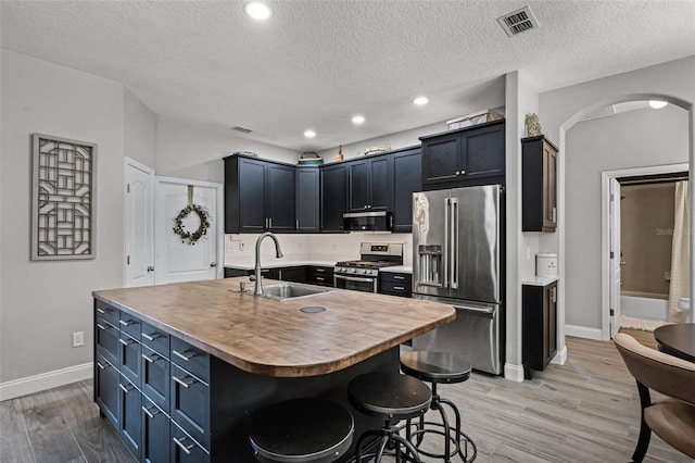 4027 Lakeside Reserve Ct, Orlando, FL 32810 - kitchen with a sink, stainless steel appliances, baseboards, arched walkways, and light wood-style floors