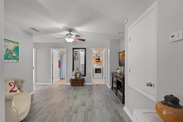 4027 Lakeside Reserve Ct, Orlando, FL 32810 - interior space with a textured ceiling, light wood finished floors, ceiling fan, visible vents, and washer / dryer