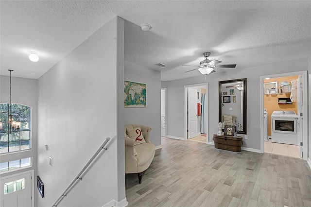 4027 Lakeside Reserve Ct, Orlando, FL 32810 - entrance foyer with a healthy amount of sunlight, light wood finished floors, a textured ceiling, and washer / dryer