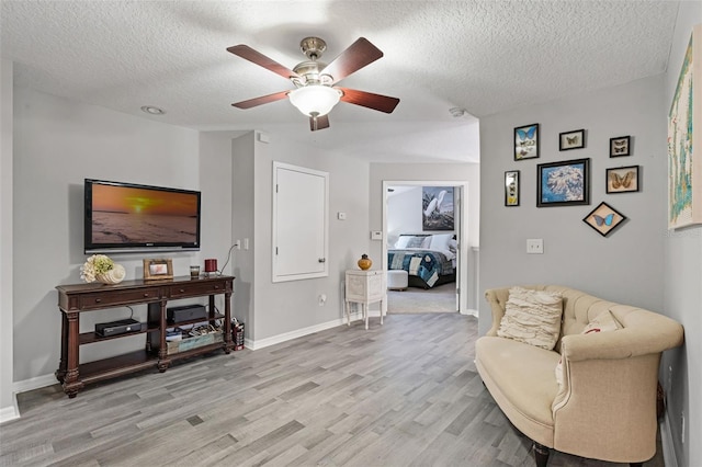 4027 Lakeside Reserve Ct, Orlando, FL 32810 - living area with light wood-style flooring, a textured ceiling, baseboards, and a ceiling fan