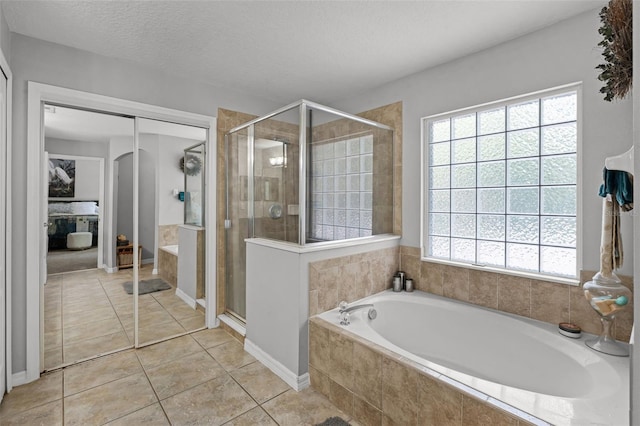 4027 Lakeside Reserve Ct, Orlando, FL 32810 - bathroom with a stall shower, a bath, and tile patterned floors