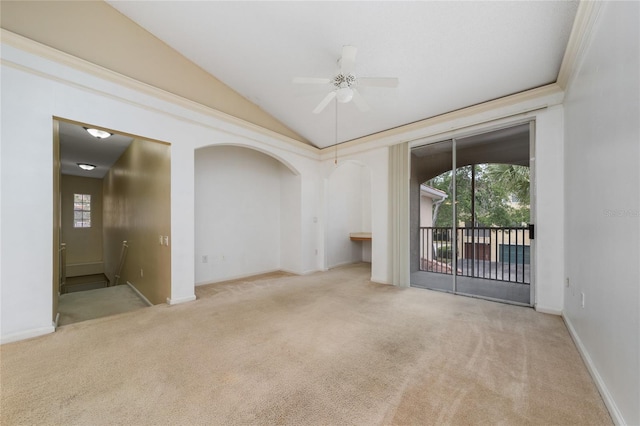 carpeted spare room with baseboards, vaulted ceiling, ceiling fan, and plenty of natural light