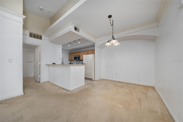 kitchen with stainless steel microwave, white fridge with ice dispenser, visible vents, and light colored carpet