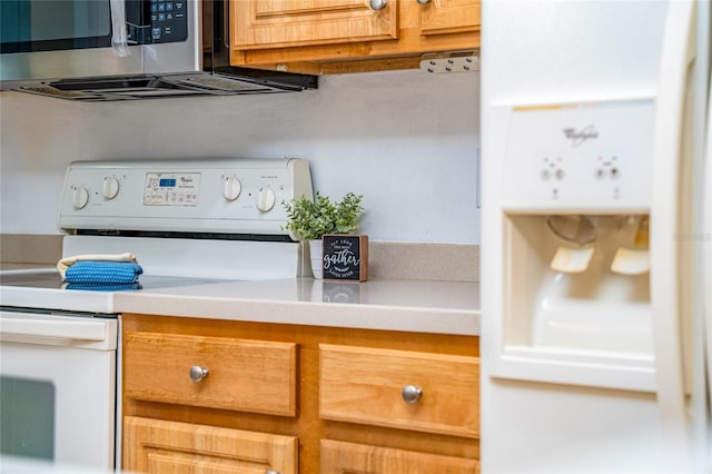 room details with electric stove, light countertops, and stainless steel microwave