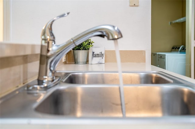 interior details with washer and clothes dryer, light countertops, and a sink