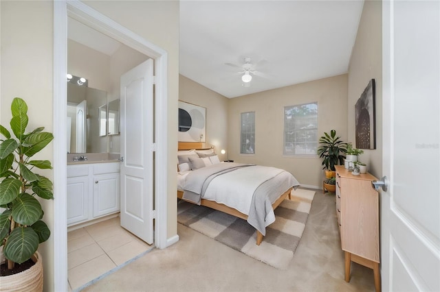 bedroom with ceiling fan, ensuite bathroom, baseboards, and a sink