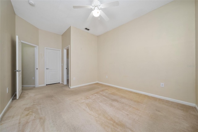 unfurnished bedroom with a ceiling fan, visible vents, light colored carpet, and baseboards
