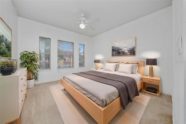 bedroom featuring ceiling fan, light carpet, and baseboards
