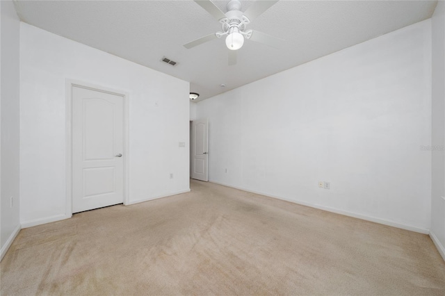 spare room featuring baseboards, visible vents, ceiling fan, and carpet
