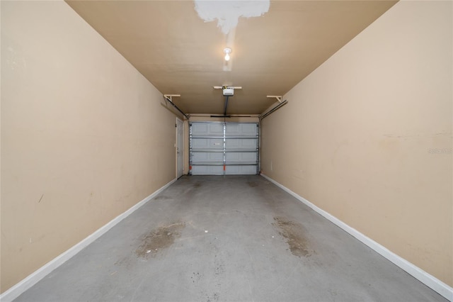 garage with a garage door opener and baseboards