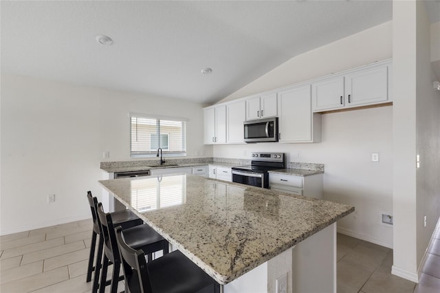 3222 Sweet Acres Pl, Saint Cloud, FL 34772 - kitchen featuring appliances with stainless steel finishes, light stone counters, a sink, a kitchen island, and vaulted ceiling