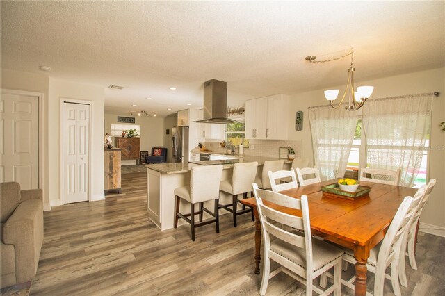 1529 Glastonberry Rd, Maitland, FL 32751 - dining area with wood finished floors, a chandelier, baseboards, a textured ceiling, and recessed lighting