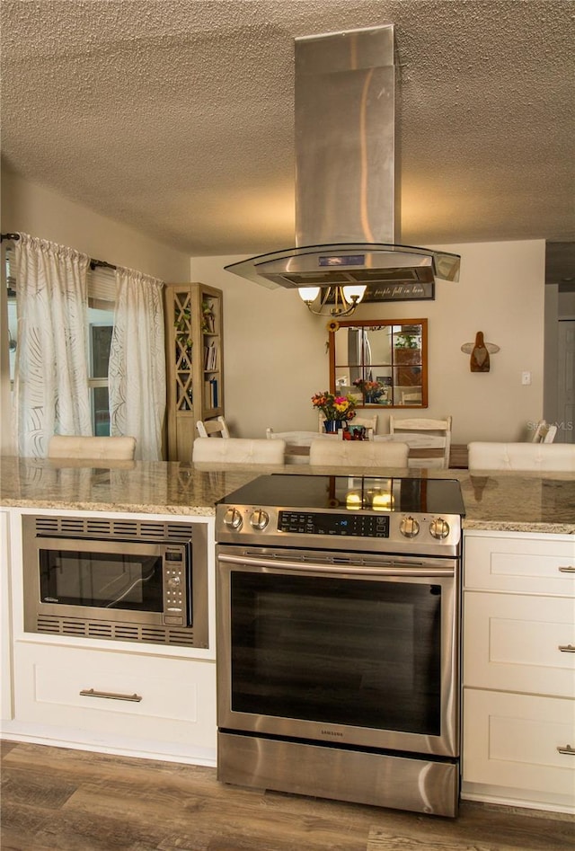 1529 Glastonberry Rd, Maitland, FL 32751 - kitchen featuring appliances with stainless steel finishes, island exhaust hood, a textured ceiling, dark wood-style floors, and white cabinetry