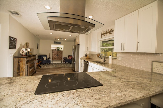 1529 Glastonberry Rd, Maitland, FL 32751 - kitchen with appliances with stainless steel finishes, a sink, white cabinets, light stone counters, and a textured ceiling