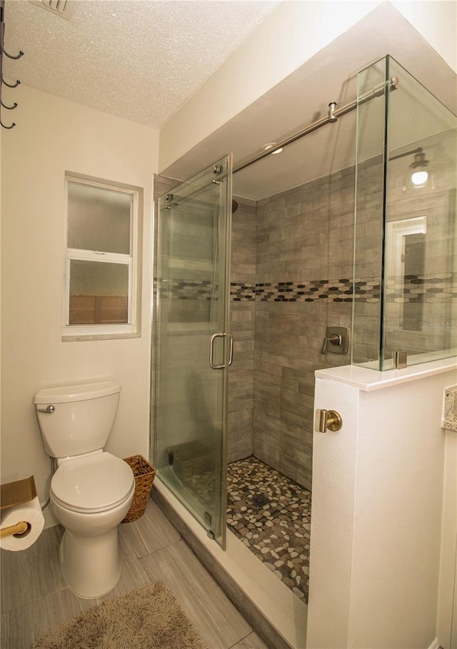 1529 Glastonberry Rd, Maitland, FL 32751 - bathroom featuring a stall shower, toilet, and a textured ceiling
