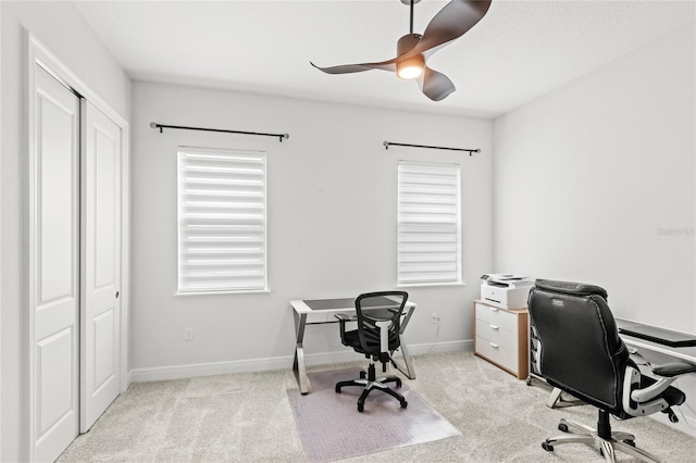 carpeted office featuring baseboards, ceiling fan, and a healthy amount of sunlight