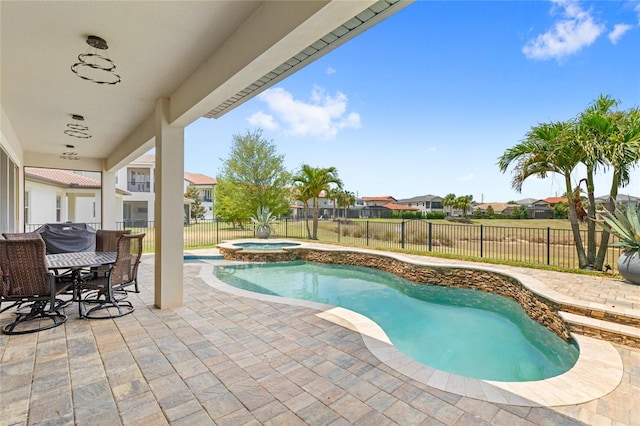 view of pool with a residential view, a fenced backyard, a pool with connected hot tub, and a patio area