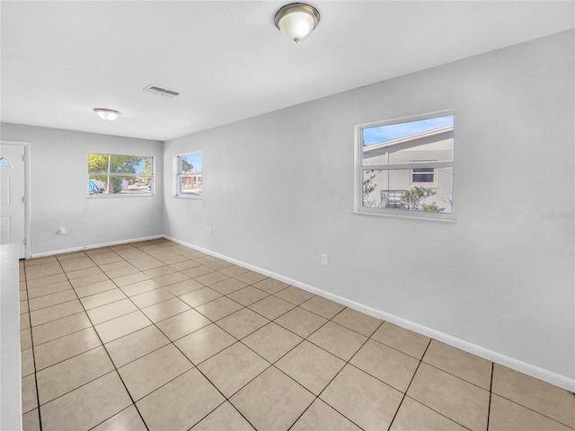 spare room with light tile patterned floors, visible vents, and baseboards