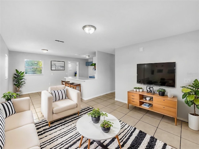 living room with light tile patterned flooring, visible vents, and baseboards