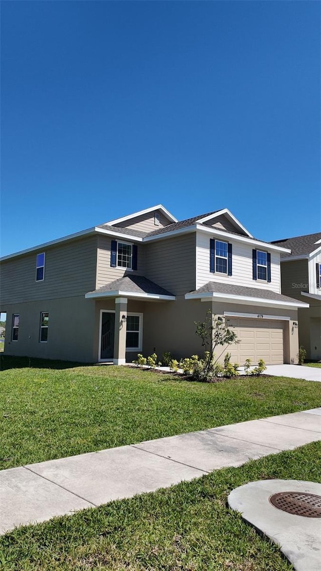 traditional-style home featuring a garage, stucco siding, concrete driveway, and a front yard
