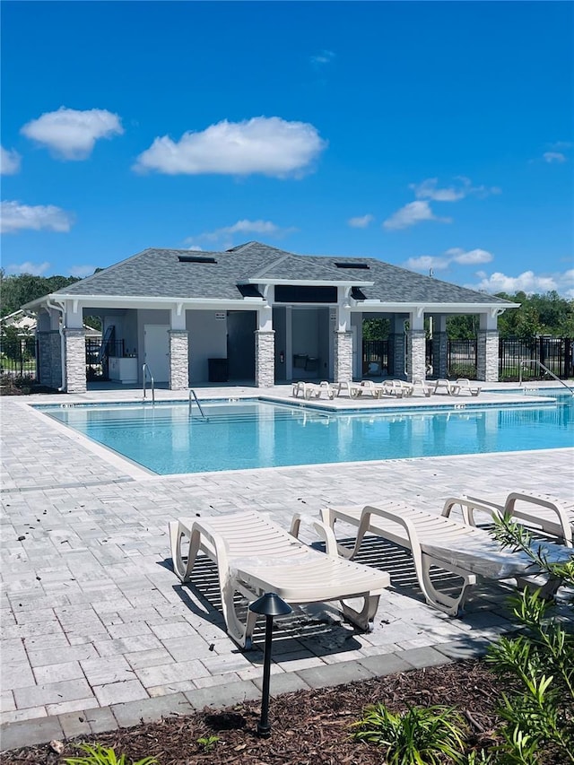 pool featuring fence and a patio