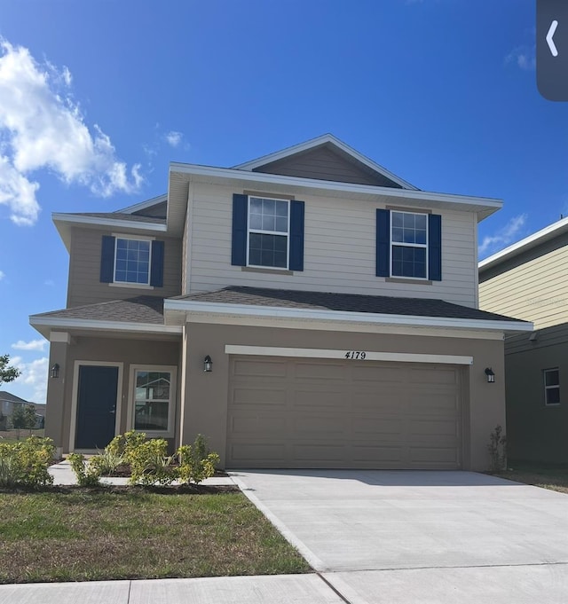 traditional home with a garage, stucco siding, and driveway