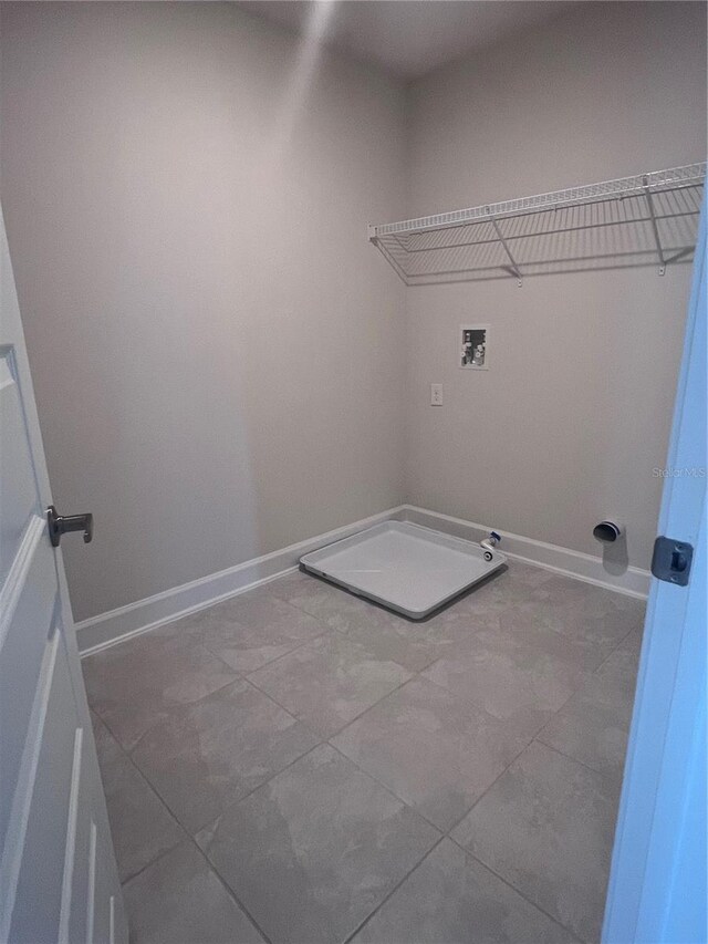 laundry room featuring laundry area, tile patterned floors, washer hookup, and baseboards