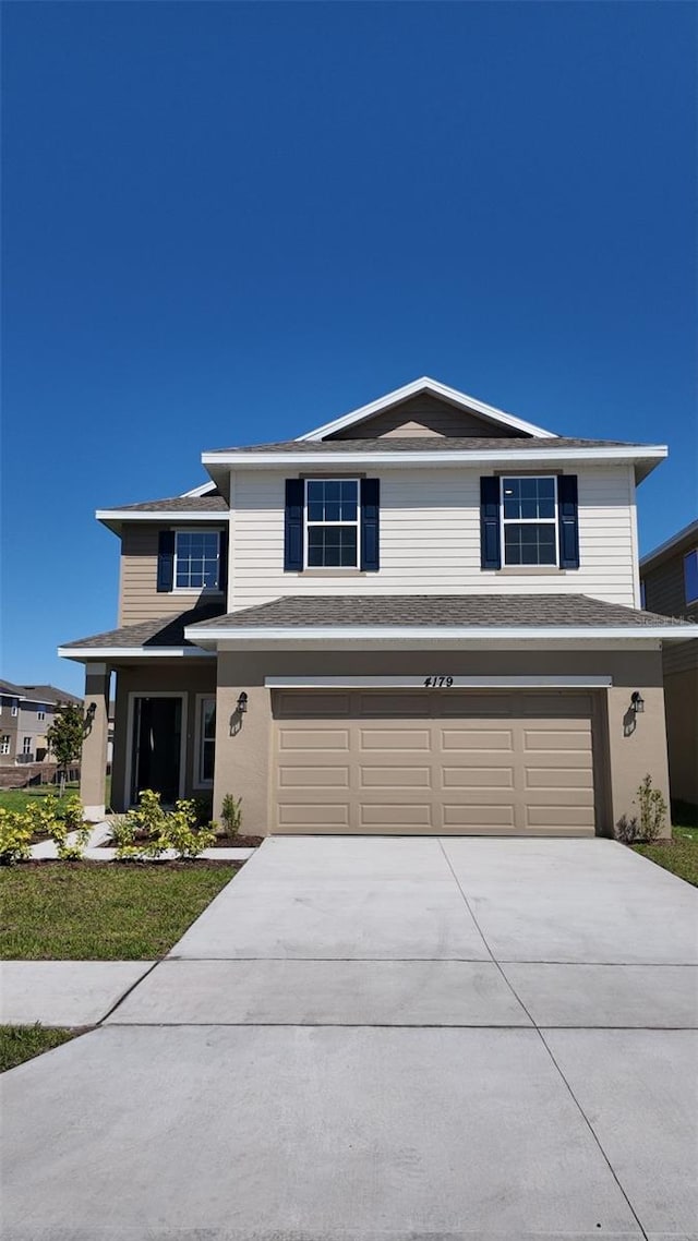 traditional home with an attached garage and concrete driveway