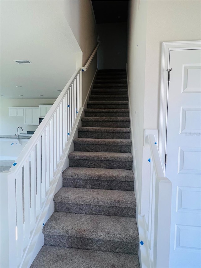staircase featuring visible vents and baseboards