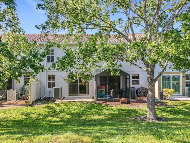 back of property featuring stucco siding, central AC unit, and a yard