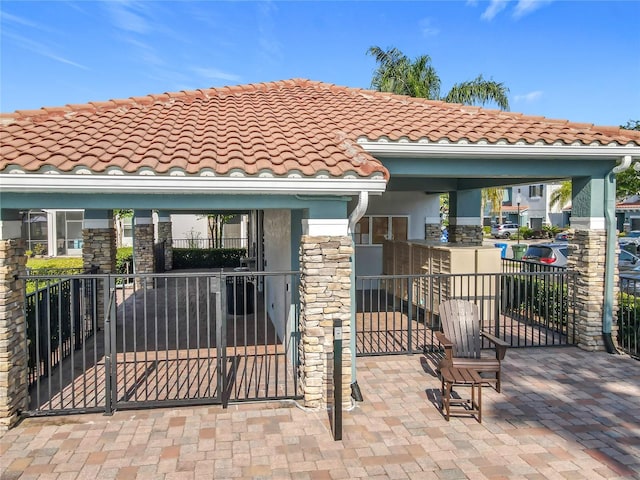 exterior space featuring stucco siding, a tiled roof, and stone siding