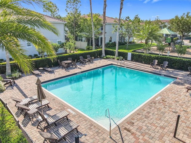 pool with a patio and fence