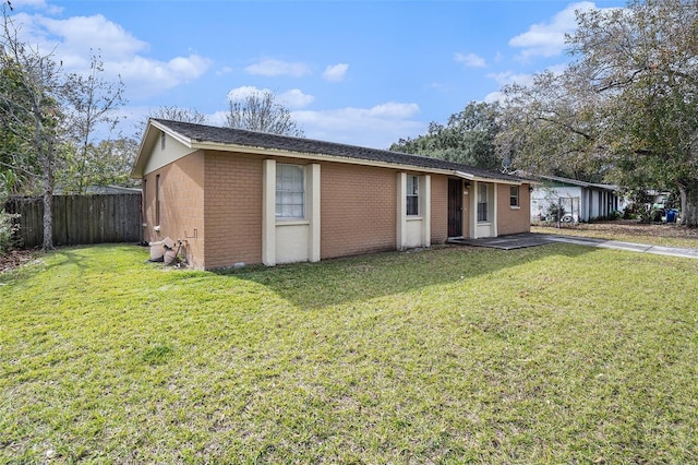 ranch-style house with brick siding, a front lawn, and fence