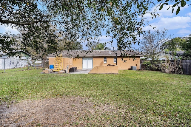 rear view of house with a lawn, a shingled roof, a fenced backyard, and central air condition unit