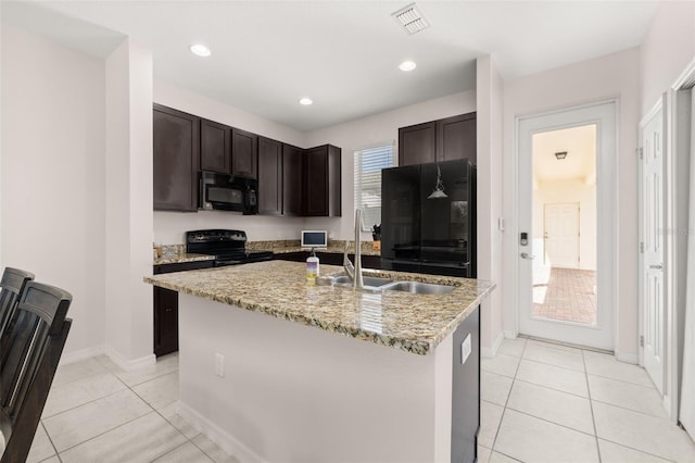 kitchen featuring dark brown cabinetry, light tile patterned floors, black appliances, a sink, and visible vents