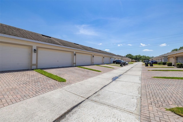 view of road featuring community garages