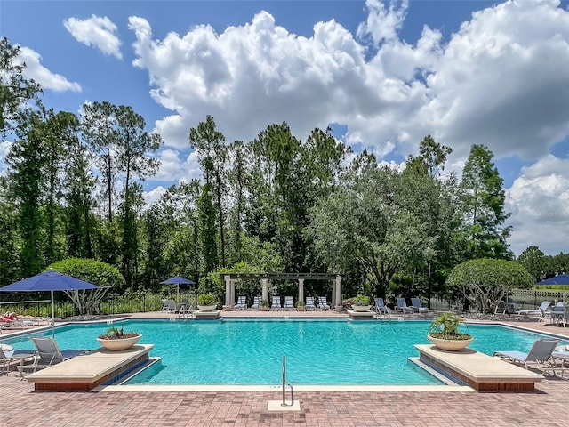 pool with fence and a patio