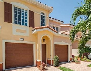 20310 Estero Gardens Cir Unit 203, Estero, FL 33928 - mediterranean / spanish-style house with stucco siding, a garage, driveway, and a tiled roof