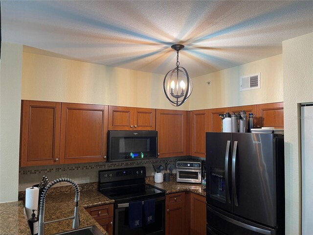 20310 Estero Gardens Cir Unit 203, Estero, FL 33928 - kitchen with black appliances, a chandelier, tasteful backsplash, brown cabinetry, and a sink