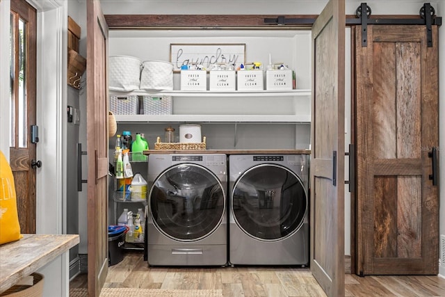 2105 Fosgate Dr, Winter Park, FL 32789 - laundry area with a barn door, light wood-type flooring, laundry area, and independent washer and dryer