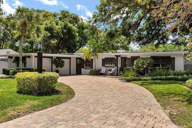 2105 Fosgate Dr, Winter Park, FL 32789 - ranch-style home with a front yard, decorative driveway, stucco siding, and a garage