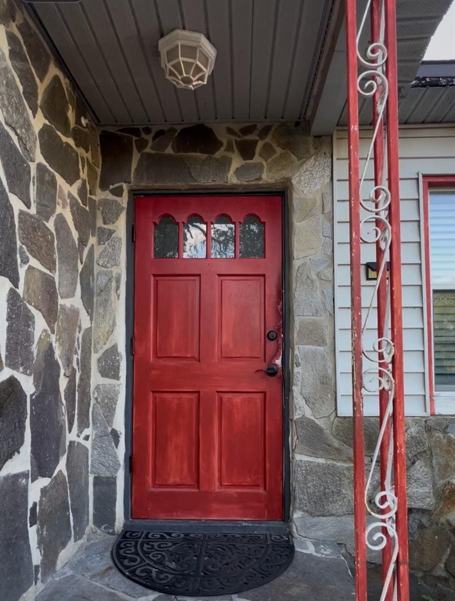 doorway to property with stone siding