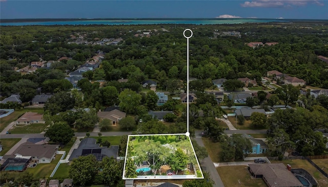 drone / aerial view with a water view, a view of trees, and a residential view