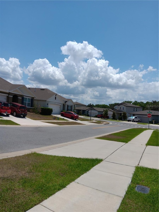view of street featuring traffic signs, a residential view, and sidewalks