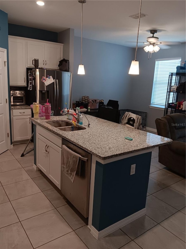 kitchen with light tile patterned flooring, appliances with stainless steel finishes, an island with sink, and a sink