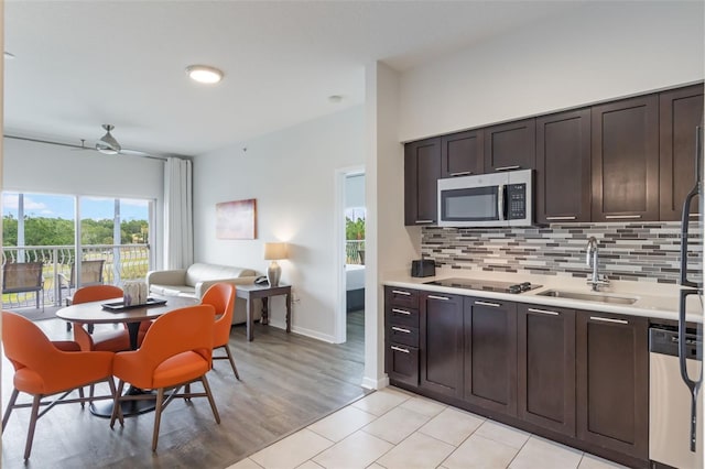 225 Celebration Pl Unit 401, Kissimmee, FL 34747 - kitchen featuring a sink, stainless steel appliances, light countertops, tasteful backsplash, and dark brown cabinetry