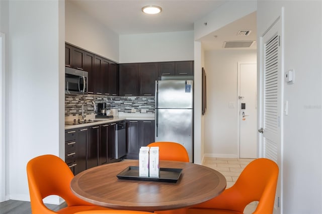 225 Celebration Pl Unit 401, Kissimmee, FL 34747 - kitchen featuring appliances with stainless steel finishes, light countertops, dark brown cabinetry, tasteful backsplash, and light tile patterned floors