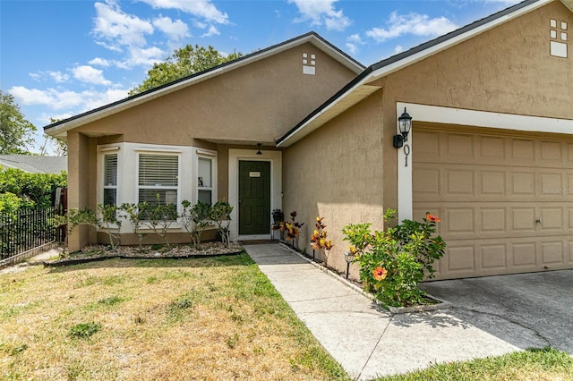 view of front of property featuring a garage, fence, and stucco siding