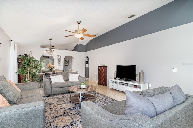 living area with light tile patterned flooring, ceiling fan, arched walkways, lofted ceiling, and visible vents